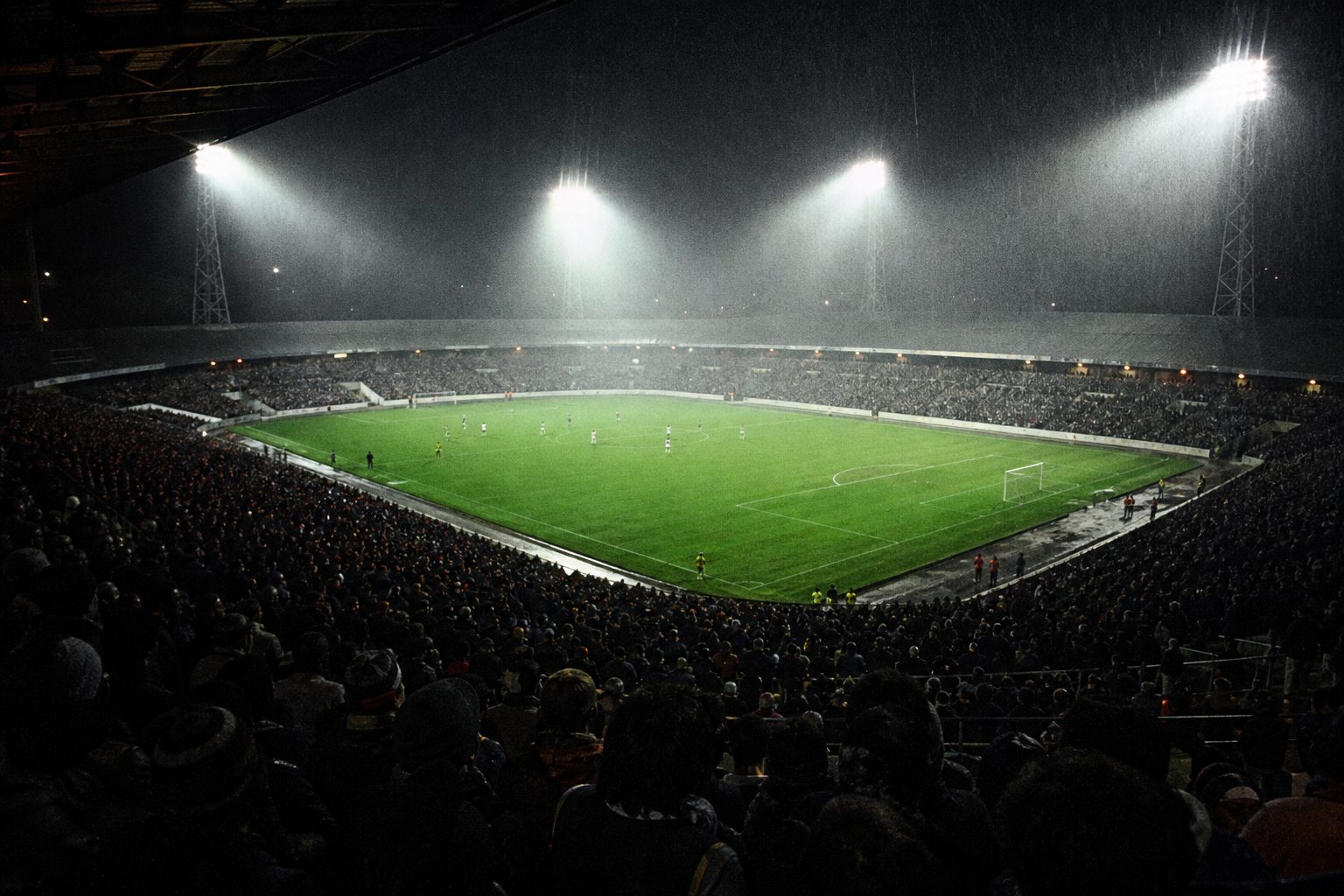 Floodlights blazing through drizzle over a packed football ground at night (picture made with AI)